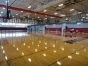The gymnasium at the Kroc Center is 2 wood courts and 2 synthetic courts with divider curtains. Over one of the synthetic courts there are baseball batting cages that lower from the ceiling.